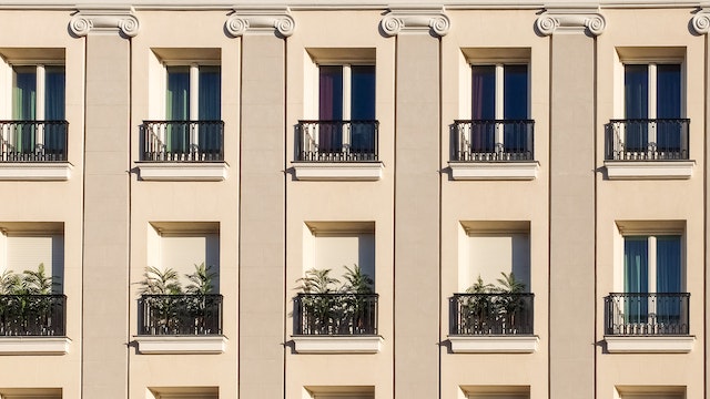 a wall of outdoor balconies with plants 